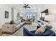 Well-lit living room features a couch, TV, large windows, and a ceiling fan at 3027 Bermuda Sloop Cir, Ruskin, FL 33570
