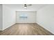 Well-lit bedroom with wood-look flooring and a large window at 31814 Oyster Trellis Ln, Wesley Chapel, FL 33545
