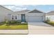One-story home with gray siding, teal door, and landscaped lawn at 31814 Oyster Trellis Ln, Wesley Chapel, FL 33545