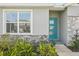 Modern home exterior with teal front door and stone accents at 31814 Oyster Trellis Ln, Wesley Chapel, FL 33545