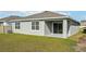 Rear view of house showing a covered patio and AC unit at 31814 Oyster Trellis Ln, Wesley Chapel, FL 33545