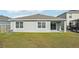 Rear view of house with covered patio and grassy yard at 31814 Oyster Trellis Ln, Wesley Chapel, FL 33545