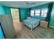 Bedroom with light teal walls, laminate flooring and a double bed at 34212 Canal N Dr # B, Pinellas Park, FL 33781
