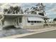 White single-wide manufactured home with carport and landscaped yard at 34212 Canal N Dr # B, Pinellas Park, FL 33781