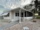 White manufactured home with screened porch and landscaped yard at 34212 Canal N Dr # B, Pinellas Park, FL 33781