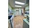 Galley kitchen with light green cabinets, vinyl flooring, and black appliances at 34212 Canal N Dr # B, Pinellas Park, FL 33781