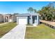 New construction home features a gray exterior, white garage door, and a stone driveway at 3515 55Th Ave N, St Petersburg, FL 33714