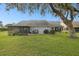 Home features a backyard with screened patio, grill, and lush lawn at 3624 Muirfield Ct, New Port Richey, FL 34655