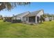 Spacious backyard with screened patio, lush lawn, and mature trees at 3624 Muirfield Ct, New Port Richey, FL 34655