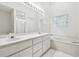 Bathroom with double vanity, soaking tub, and glass block window at 3624 Muirfield Ct, New Port Richey, FL 34655