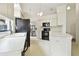 Kitchen with white cabinets, black appliances, and a view to dining area at 3624 Muirfield Ct, New Port Richey, FL 34655