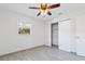 Bright bedroom featuring modern ceiling fan, light gray flooring, a window with a view, and a spacious closet at 364 3Rd Nw St, Largo, FL 33770