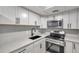 Modern kitchen with white shaker cabinets, quartz countertops, and stainless steel appliances at 4001 58Th N St # 26C, St Petersburg, FL 33709