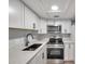 Modern kitchen with white cabinets, quartz countertops, and stainless steel appliances at 4001 58Th N St # 26C, St Petersburg, FL 33709