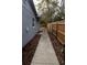 Side yard access with concrete walkway and wood chip ground cover at 438 E Martin Luther King Jr Dr, Tarpon Springs, FL 34688