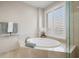 Relaxing bathroom featuring a large soaking tub and window with shutters at 470 Mandalay Ave # 305, Clearwater Beach, FL 33767
