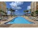 Resort-style pool with ocean view and lounge chairs at 470 Mandalay Ave # 305, Clearwater Beach, FL 33767