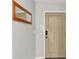 Interior entryway with a tan door and wall-mounted mirror at 4711 Cypress Tree Dr, Tampa, FL 33624