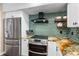 Modern kitchen with stainless steel appliances and green tile backsplash at 5166 39Th S St, St Petersburg, FL 33711