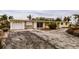 Ranch-style home undergoing renovation, featuring a large driveway and tropical landscaping at 601 Ambassador Ln, Holmes Beach, FL 34217