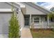 Front entrance with a gray exterior, white railing, and walkway at 6069 Newmark St, Spring Hill, FL 34606