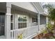 Front porch with white railings, gray exterior, and windows at 6069 Newmark St, Spring Hill, FL 34606