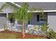 Front porch with white railing, landscaping, and a palm tree at 6069 Newmark St, Spring Hill, FL 34606