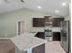 U-shaped kitchen with granite countertops and dark cabinets at 6069 Newmark St, Spring Hill, FL 34606