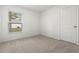 Well-lit bedroom with neutral carpeting and closet at 7220 Swartburg Rd, North Port, FL 34291