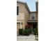 Tan two-story townhome with landscaping and a black front door at 8431 Edgewater Place Blvd, Tampa, FL 33615