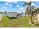 Large backyard with grass, trees and a patio at 105 3Rd St, Belleair Beach, FL 33786