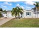 Newly renovated home with a charming facade, landscaped lawn, and paver driveway at 105 3Rd St, Belleair Beach, FL 33786