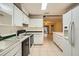 Kitchen with white cabinets, black appliances, and access to backyard at 1207 Eastloch Ct, Sun City Center, FL 33573