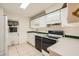 Kitchen features white cabinets, black appliances, and tile flooring at 1207 Eastloch Ct, Sun City Center, FL 33573