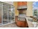 Outdoor kitchen with granite countertops, stainless steel appliances, and built-in grill at 15005 Lake Emerald Blvd, Tampa, FL 33618