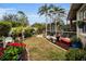 Backyard oasis featuring a screened patio, lush landscaping, and charming garden accents at 1531 Riverdale Dr, Oldsmar, FL 34677