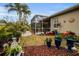 Outdoor space with screened patio, landscaping, and colorful potted plants at 1531 Riverdale Dr, Oldsmar, FL 34677