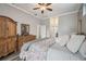 Main bedroom with a king-size bed, wooden dresser, and ceiling fan at 1551 Daylily Dr, Trinity, FL 34655