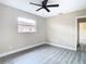 Bedroom with wood-look floors, window, and ceiling fan at 1612 Fox Run Dr, Tarpon Springs, FL 34689