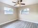 Well-lit bedroom with wood-look floors and two windows at 1612 Fox Run Dr, Tarpon Springs, FL 34689