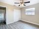 Bedroom with wood-like floors, window, and ceiling fan at 1612 Fox Run Dr, Tarpon Springs, FL 34689