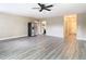 Spacious living room with wood-look floors, ceiling fan, and kitchen view at 1612 Fox Run Dr, Tarpon Springs, FL 34689