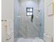 Elegant bathroom with walk-in shower, marble tile, and frameless mirror at 2549 Martha Ln, Land O Lakes, FL 34639
