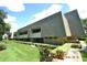 Exterior view of the building with landscaping and lawn at 36750 Us Highway 19 N # 23120, Palm Harbor, FL 34684
