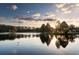 Stunning sunset over a calm lake with trees reflecting in the water at 36750 Us Highway 19 N # 23120, Palm Harbor, FL 34684