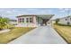 Single-wide manufactured home with carport and landscaped lawn at 36905 Beth Ave, Zephyrhills, FL 33542