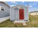 Gray shed with red door and wood steps at 36905 Beth Ave, Zephyrhills, FL 33542