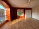 Empty bonus room with hardwood floors, built-in shelving, and natural light from a large window at 4161 Grandchamp Cir, Palm Harbor, FL 34685