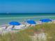 Relaxing beach scene with blue umbrellas and lounge chairs at 458 Grant St, Dunedin, FL 34698