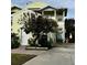 Two-story yellow house with a white garage door and landscaping at 458 Grant St, Dunedin, FL 34698